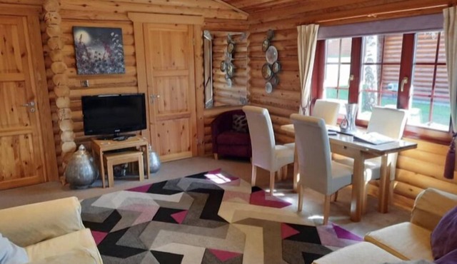 Lakeside Log Cabin with hot tub overlooking the water.