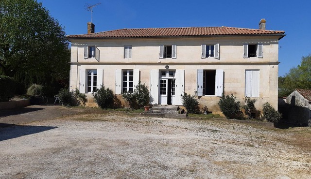 Large freestone house surrounded by large green spaces