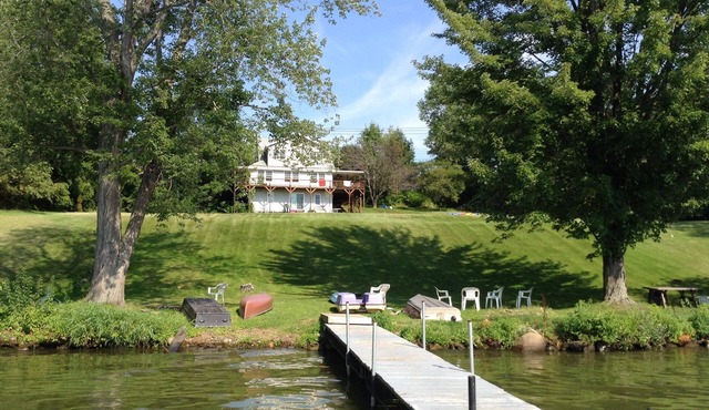 Large Lakefront Reunion And Retreat Home With a large lawn and wrap around porch