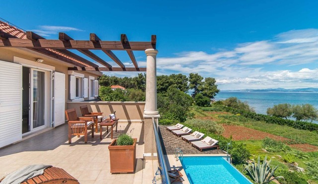 Luxury 6-BR Waterfront Villa with Infinity Pool and direct access to a pebble beach