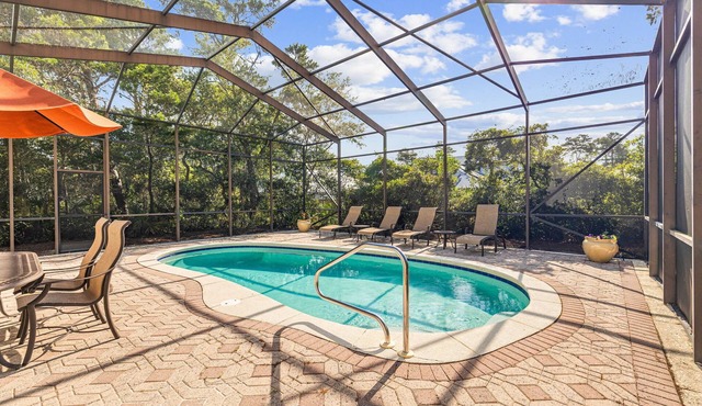 Luxury retreat with screened pool, outdoor kitchen & dining, and coastal charm