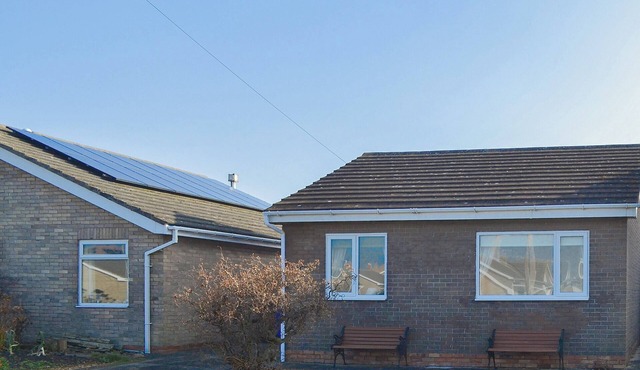 Modern accommodation with sun room and patio overlooking a small lake.