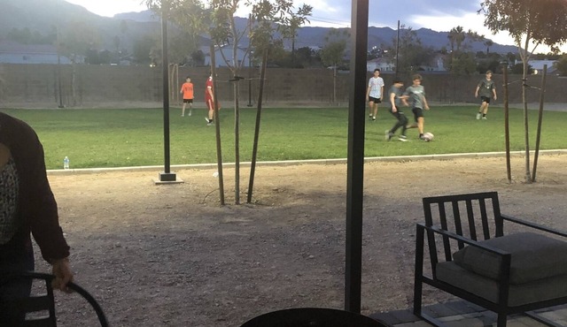 Modern container home in Las Vegas with own soccer field and trees.