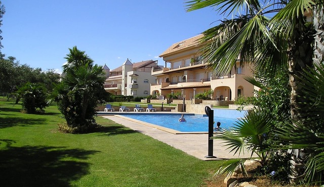 Modern duplex house overlooking communal pool and gardens at Golf Panoramica.