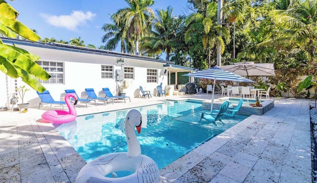 Modern Hollywood Beach villa with a private heated saltwater pool, hot tub, and spacious family-friendly layout. Just 1 mile from the ocean & Broadwalk, featuring a full kitchen, open living areas, and tropical outdoor lounge spaces.