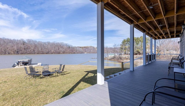 Modern lakefront home with wraparound decks, firepit, and stunning water views on both levels.