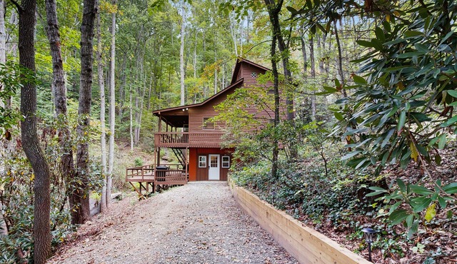 Mountain home nestled in the forest with a stream, deck, firepit, & game room