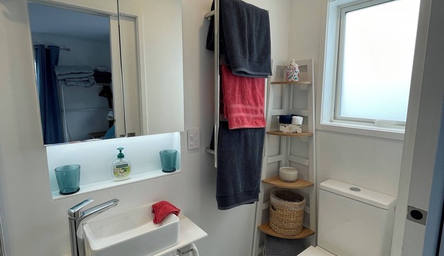 Newly finished self-contained unit above Arkles Bay watch sunset over Auckland