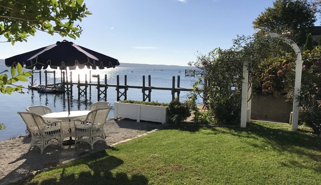 Old fashioned designer front porch living by the sea with expansive water views.