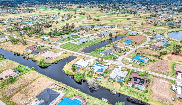 Palm-lined waterfront retreat with enclosed pool, inviting patio, & central AC