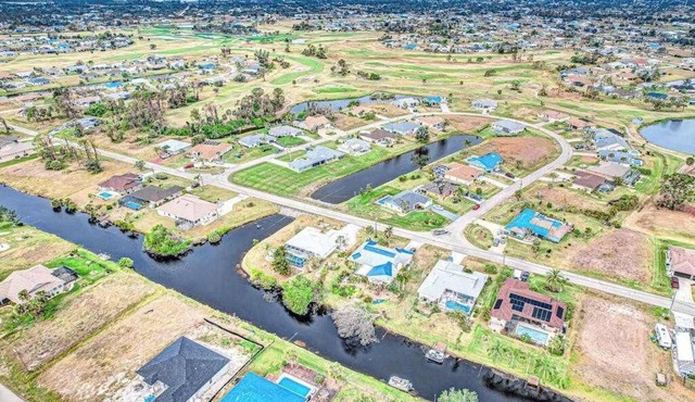 Palm-lined waterfront retreat with enclosed pool, inviting patio, & central AC