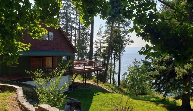 Peaceful home enveloped in a quiet, scenic landscape adjacent to a rocky beach.