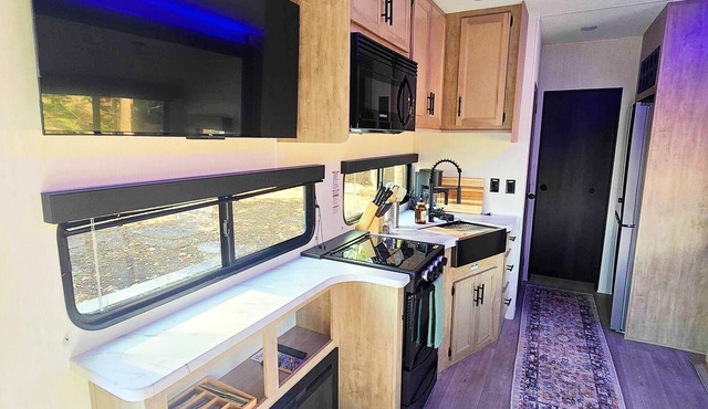 Premium Cabin-Style RV - The Evergreen (Sleeps 7) - Warm cabin-style retreat with queen bed, bunkroom, kitchen fireplace & skylight bath — perfect for families.