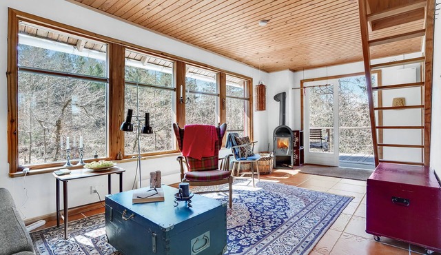 Relaxed living in tranquil wooden cottage near forest and meadows.