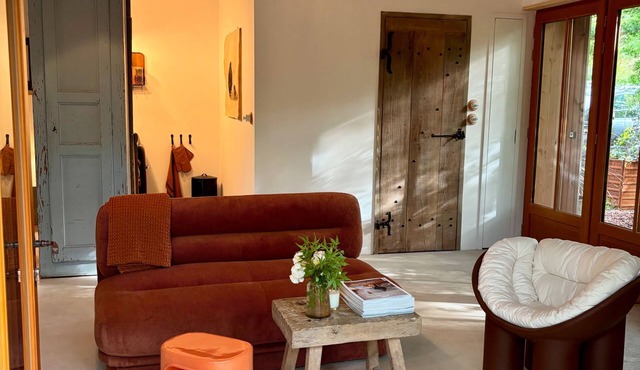 Renovated barn in the trees with terrace on stilts surrounded by vegetation