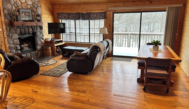 Riverbend Retreat Middle Branch CottagenFireplace and hot tub with river view.
