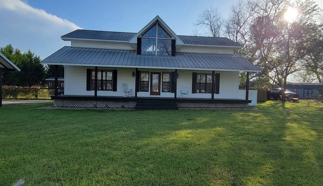 Rocking Chair front porch looking out on sprawling pecan trees filled w/nature.