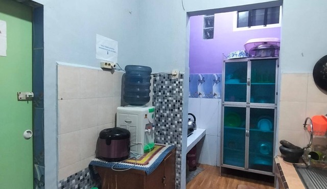 Rumah dua lantai berwarna biru cerah tampak bercahaya di malam hari