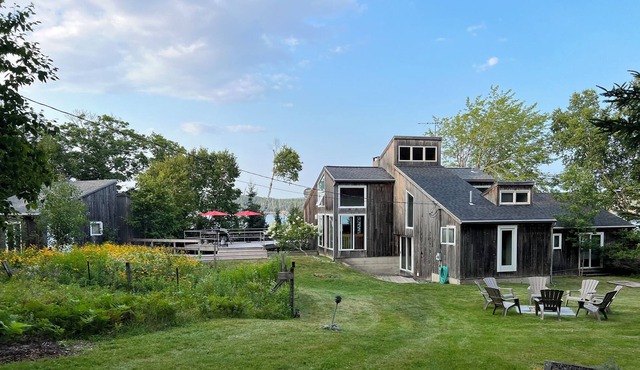 Rustic home with guest houses along a private beach in Little Deer Isle, Maine.