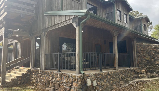 Rustic Lodge with a view of open pastures and bison grazing on the land.
