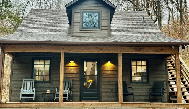 Secluded cabin next to creek with hot tub + fire pit. Walking distance to river.