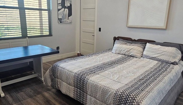 Serene large bedroom with private entrance, bathroom, and thermostat.