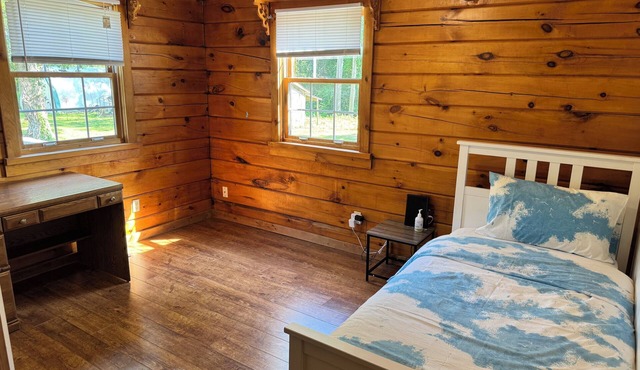 Serene log home on spacious land with trees and a small farm.
