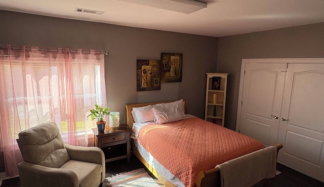 Spacious bedroom with closet, tv and full bed, along with apartment amenities.