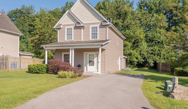 Spacious family home with multiple bedrooms, full kitchen, porch, and quaint backyard.