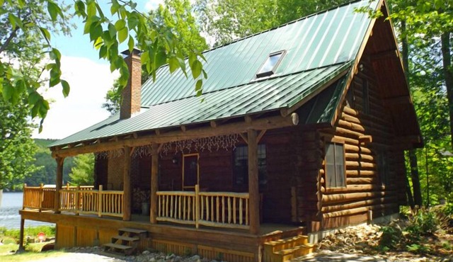 Spacious log cabin with 600' of water frontage on picturesque Moose Pond.