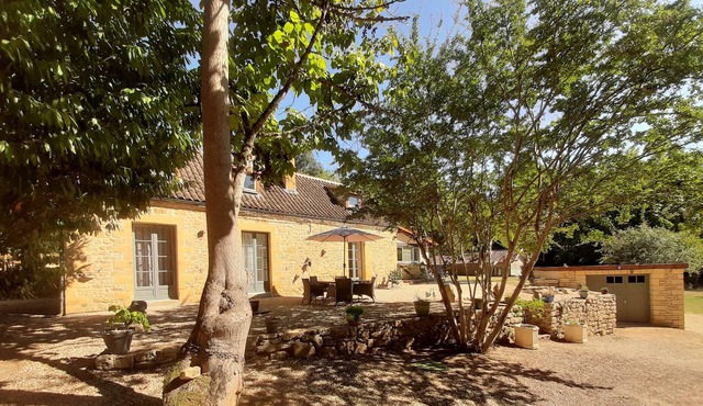 Stone farmhouse surrounded by woodland
