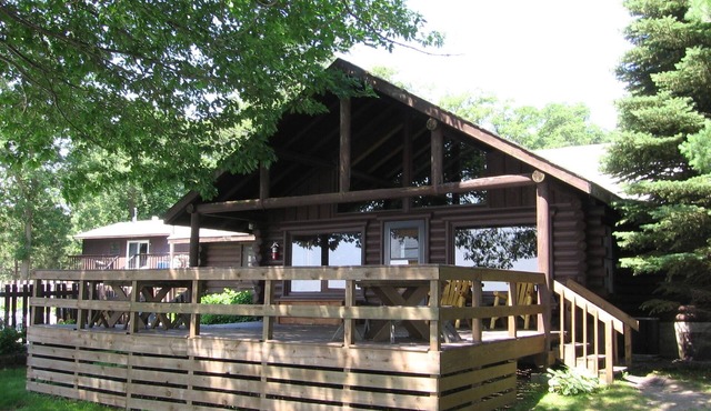 Stunning Log Home on the water's edge with deck overlooking the swimming pool.