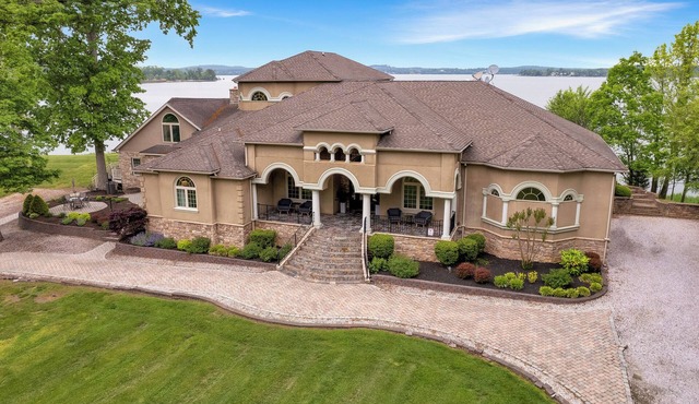 Stunning waterfront villa with indoor pool and kids swing set and play area.