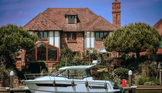 Stunning waterside six-bed house with water views, gardens and private jetty