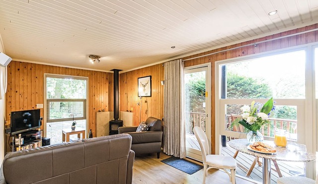 Stylish open plan lodge with king-size four poster bed.