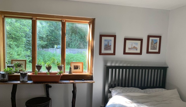Sunny bedroom with full bed and private bathroom.