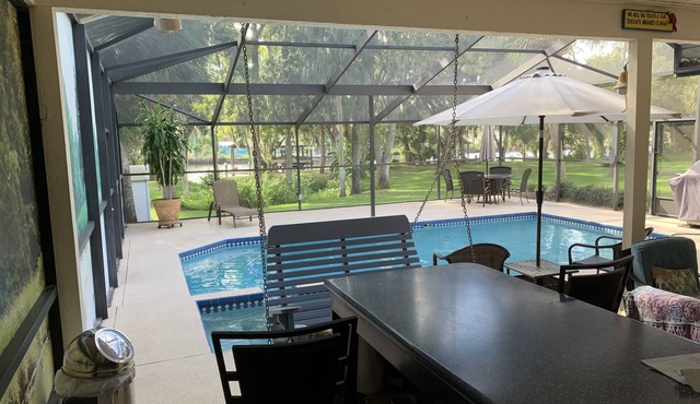 Tampa area home with solar-heated pool, hot tub, river and large dock.