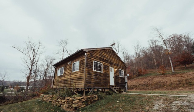The Hideout - Escape to The Hideout in Hocking Hills, OH! This cozy, pet-friendly cabin offers a private deck by Pine Creek, just minutes from hiking, waterfalls, and caves. Perfect for up to 4 guests. Book your nature-filled getaway today!