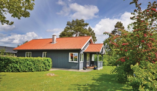 The spacious and well-maintained cottage is situated on a beautiful plot with tall trees.