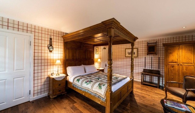 The wooden floors, vintage furniture, and tartan accents create a comfy room