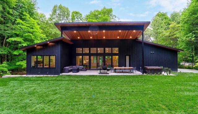 This newly built modern home is tucked in a peaceful wooded lot just minutes