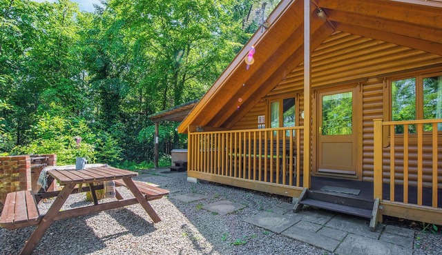 Timber lodge set in an elevated woodland position with views of the lake.