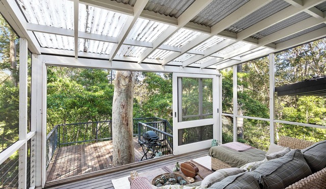 Tranquil family-sized treehouse. Ocean glimpses with outdoor deck.