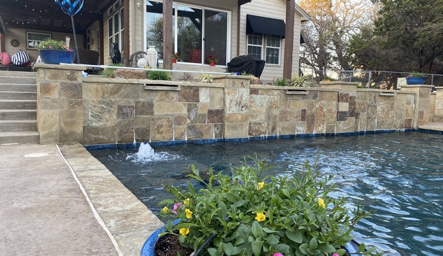 Tranquil Waterfront property with a pool, hot tub, fire-pit & large patio.