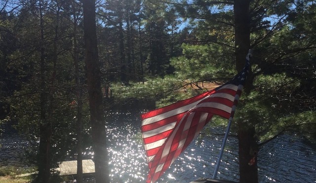 Traverse City area Lakefront Log Home, FREE Hot Tub, WIFI, & Boats.