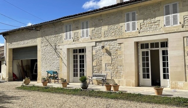 Typical Charente farmhouse with enclosed garden planted with trees.