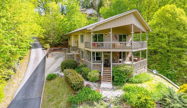 View-worthy home lined by trees with a fireplace, wrap-around deck, grill, & W/D