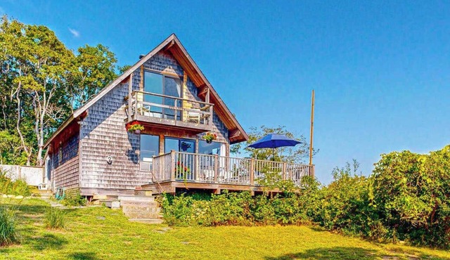 Water-view home with large deck, balcony, enclosed sunroom & peaceful location