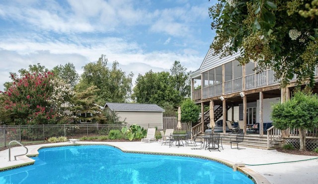 Waterfront home with swimming pool and tennis court.