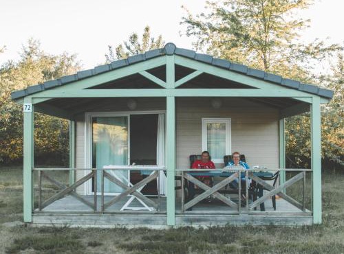 Wooden chalet with covered terrace on the edge of a lake